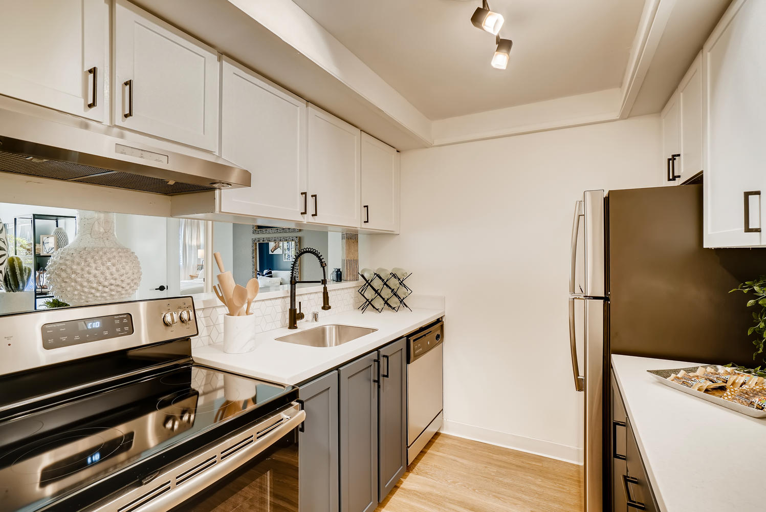 Kitchen with wooden floor, white countertops, and white cabinets