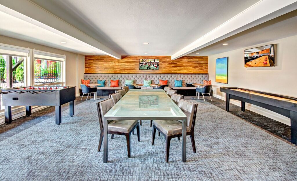 Clubhouse lounge with tables and booths at Park 120 apartments for rent near Downtown Seattle