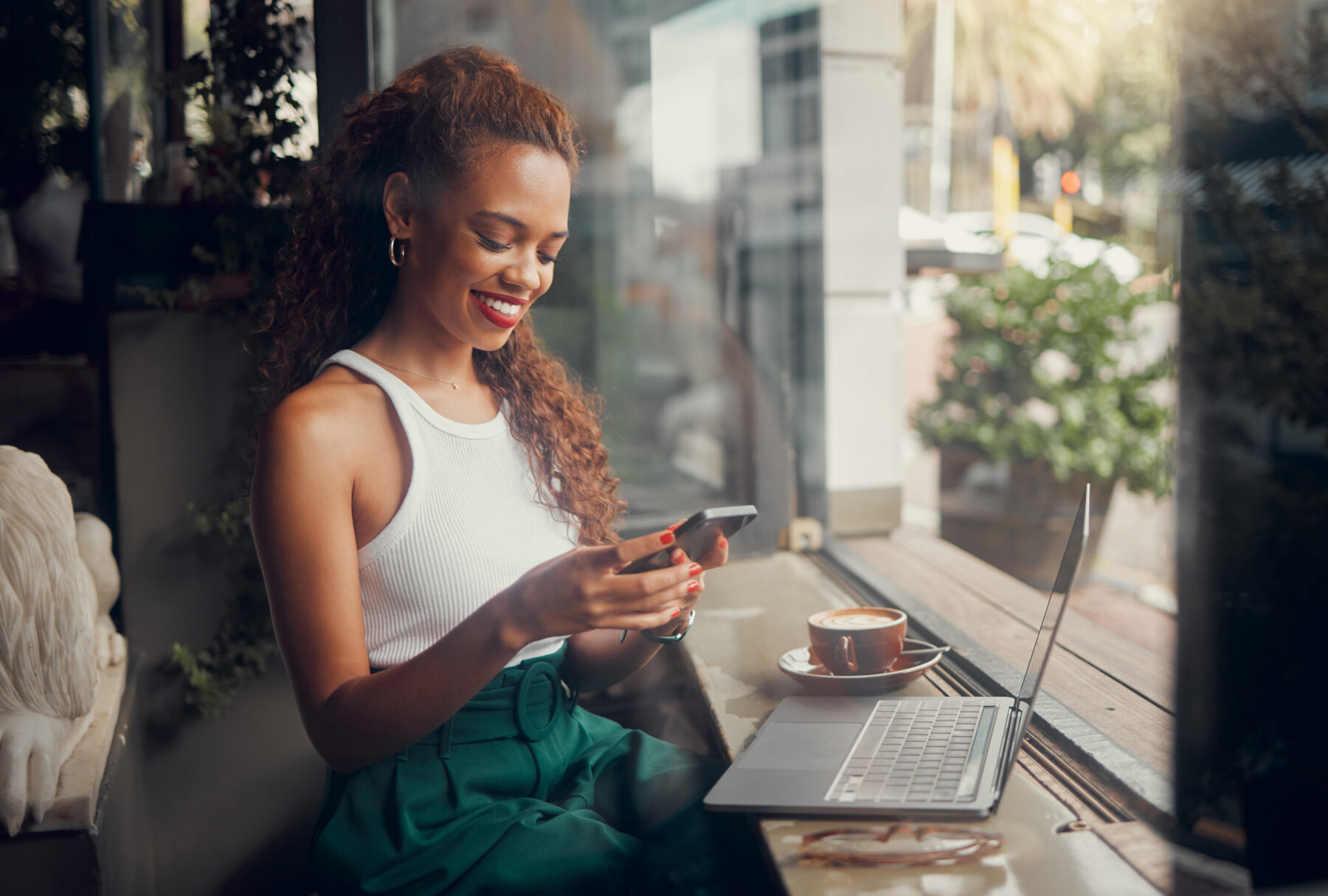 A woman in a cafe sitting at a table with a laptop